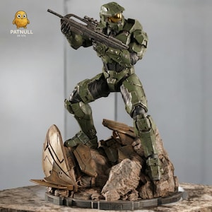Puede incluir: Una figura de acción verde de un soldado con armadura de combate, sosteniendo un rifle. La figura está posada sobre una base rocosa con un elemento de diseño futurista. La figura lleva un casco con visera dorada. El logo "PATNULL 3D STL" es visible.