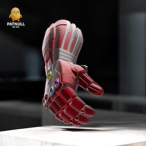 Pode incluir: Uma manopla vermelha e prateada com seis pedras preciosas coloridas incrustadas nas articulações. A manopla é um design impresso em 3D, com o texto "PATNULL 3D STL" no canto superior esquerdo. A manopla é uma réplica da Manopla do Infinito.