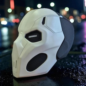 以下が含まれることがあります： 白と黒の未来的なマスクで、側面にメッシュ部分があります。 マスクは、角度のある特徴と目のための小さな長方形の開口部のシリーズを備えた洗練されたデザインです。 マスクはおそらくコスプレやコスチューム用です。