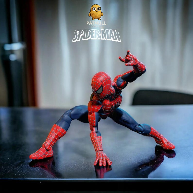 K&ouml;nnte beinhalten: Eine Spider-Man-Actionfigur in dynamischer Pose, gekleidet in einem rot-blauen Anzug. Die Figur ist mit Netzmustern detailliert und vor einem verschwommenen Hintergrund platziert. Der Text "PATULL SPIDER-MAN" ist sichtbar.