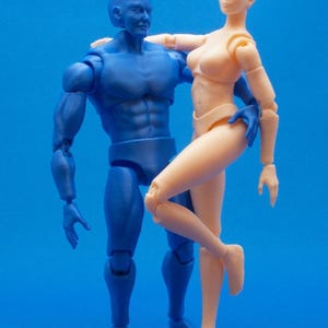 May include: Two articulated action figures, one blue and one flesh-toned, posed together against a blue backdrop. The blue figure has a muscular build, while the flesh-toned figure is in a dynamic pose.