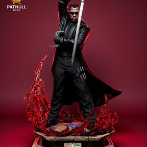 May include: A detailed figurine of a character in a black leather coat, sunglasses, and holding a sword. The figure stands on a decorative base with red flame-like accents. The logo "PATNULL 3D STL" is visible in the top left corner.