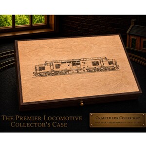 May include: A wooden collector's case featuring a detailed engraving of a locomotive on the lid. The case is brown with a dark brown frame and a brass clasp. Text on the case reads "THE PREMIER LOCOMOTIVE COLLECTOR'S CASE."
