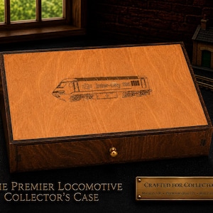 May include: A wooden collector's case with a dark brown frame and a light brown top. The top features an engraved image of an Inter-City 125 train. The case has a small gold-colored knob and the text "The Premier Locomotive Collector's Case".