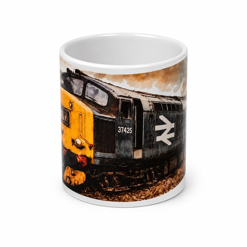 Peut inclure: Un mug en c&eacute;ramique blanche orn&eacute; d'une illustration d&eacute;taill&eacute;e d'une locomotive diesel. Le train est peint en jaune et gris fonc&eacute;, affichant le num&eacute;ro 37425 et un logo &agrave; double fl&egrave;che blanc sur le c&ocirc;t&eacute;, sur un fond textur&eacute; et enfum&eacute;.
