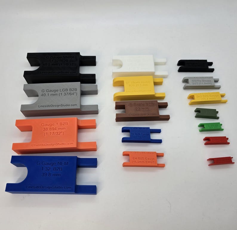 Peut inclure: Une collection de jauges d'&eacute;cartement pour roues de trains miniatures en plastique multicolore de diff&eacute;rentes tailles. Les jauges portent des mesures sp&eacute;cifiques en millim&egrave;tres et pouces, incluant G Gauge, Gauge-1, S Scale et EM B2B Gauge.