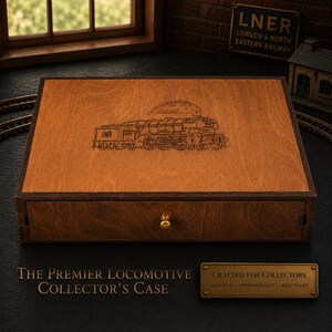 Puede incluir: Una caja de coleccionista de madera con una imagen grabada detallada de una locomotora de vapor. La caja tiene un borde marrón oscuro y un pomo de latón. El texto "THE PREMIER LOCOMOTIVE COLLECTOR'S CASE" se muestra debajo.
