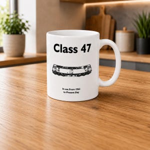 May include: A white ceramic mug featuring a black graphic illustration of a Class 47 locomotive. The text "Class 47" is printed above the train, and the text "In use From 1962 to Present Day" is printed below the train in a simple black font.
