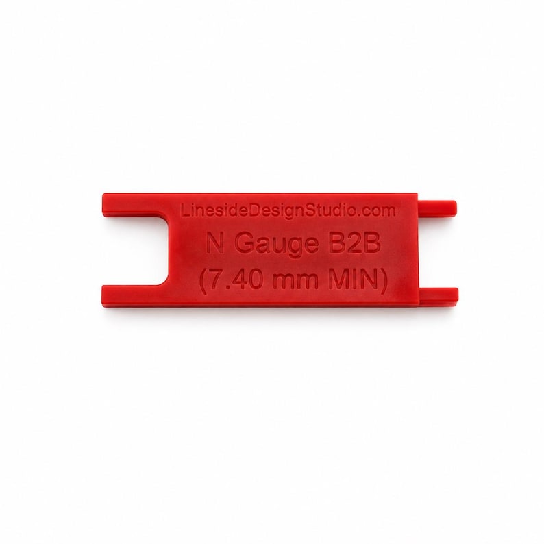 K&ouml;nnte beinhalten: Ein rotes Kunststoff-Messwerkzeug f&uuml;r den Radsatz-Innenabstand N Gauge B2B. Das Werkzeug tr&auml;gt die eingepr&auml;gten Texte LinesideDesignStudio.com, N Gauge B2B und (7.40 mm MIN). Es hat einen flachen, rechteckigen K&ouml;rper mit eingekerbten Enden.