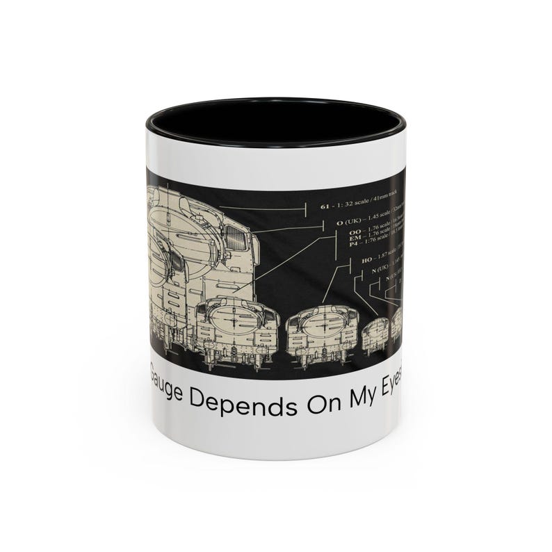 May include: A white ceramic mug with a black interior and rim, featuring a technical diagram of model train scales and the text "My Gauge Depends On My Eyesight" printed in black. The design includes various scale labels and measurements.