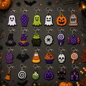 May include: A collection of twenty-four embroidered Halloween-themed keychains featuring various designs including ghosts, pumpkins, a coffin, a tombstone with RIP text, a witch hat, a cauldron, a spider web, a skull, a bat, and a haunted house.