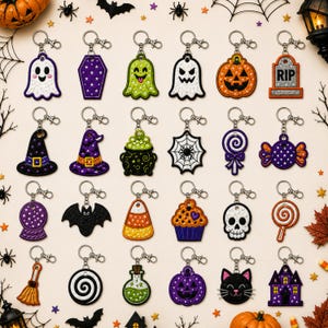 May include: A collection of twenty-four embroidered Halloween-themed keychains featuring various shapes including ghosts, pumpkins, a tombstone with RIP text, a witch hat, a cauldron, a spider web, candy, a skull, a bat, and a black cat.
