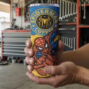 May include: A cylindrical insulated travel mug with a Spider-Man design. The mug is blue and yellow, with the words "Spider-Man Coffee" and a spider emblem. The design features the Spider-Man character. The mug is likely made of stainless steel.