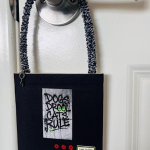 May include: A white ceramic mug with a black handle and the text "But First, Coffee" in a black, bold font. The mug is on a wooden surface. The mug is 10 cm tall.