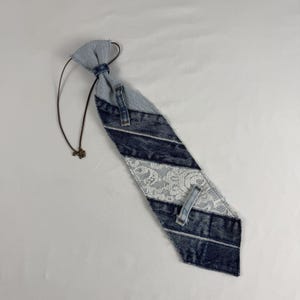 May include: A white ceramic mug with a black handle and the text "But First, Coffee" in a bold, black font. The mug is set against a blurred background, suggesting a cozy setting.