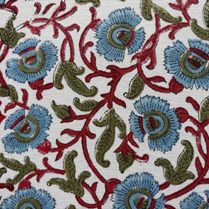 May include: A white fabric featuring a repeating floral pattern with light blue blossoms, olive green leaves, and thin red winding stems. The design is printed across the surface, showcasing a dense arrangement of botanical elements and vines.
