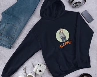 May include: Navy blue hoodie with a front pocket and a drawstring hood. The hoodie features a cartoon illustration of a person inside a green circle, with the word "FLEMME" in orange. A pair of blue jeans, sneakers, and headphones are also visible.