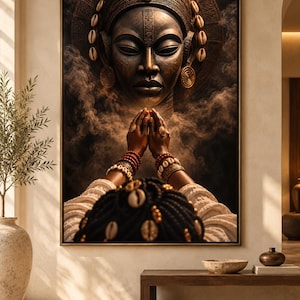 May include: A framed wall art print depicting a dark-skinned figure with braided hair adorned with cowrie shells, wearing layered beaded bracelets and rings, with hands pressed together in prayer before a large, ornate, bronze-toned mask.