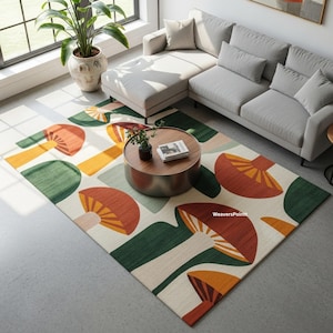 以下が含まれることがあります： クリーム色の背景に、オレンジ、緑、黄色のキノコのデザインが施された長方形のラグ。 グレーのコーナーソファと丸いコーヒーテーブルのあるリビングルームに配置されています。 ラグの寸法はセンチメートルです。