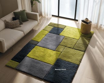 May include: A rectangular area rug featuring a geometric block pattern in shades of lime green, olive green, and charcoal gray. The rug has a thick, textured pile and includes the text Weavers Pointt printed in white on one of the gray blocks.