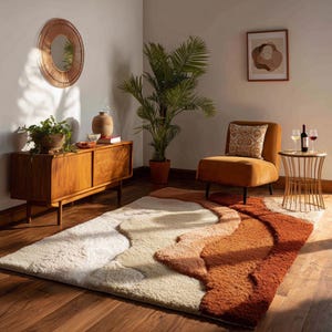 May include: A rectangular area rug featuring a textured, multi-level pile with abstract, flowing wave patterns in shades of cream, beige, terracotta, and deep rust, laid out on a dark wood floor in a room with a wooden sideboard and an orange chair.