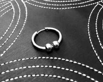 Modular stainless steel hoop earring with hollow beads.