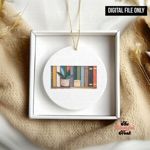 Puede incluir: Adorno redondo de cerámica blanca con una ilustración de acuarela de una estantería con una planta en maceta y una vela. El adorno está en una caja blanca con una cuerda dorada. El texto "DIGITAL FILE ONLY" está en la parte superior.