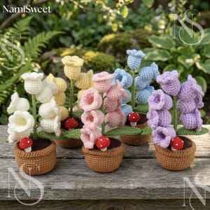 Puede incluir: Una colección de flores de ganchillo hechas a mano en varios colores, incluyendo blanco, amarillo, rosa, azul y morado. Cada flor está en una maceta de ganchillo marrón con un acento de hongo rojo. El fondo presenta vegetación y el texto "NamiSweet".