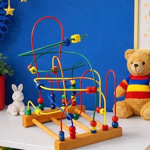 May include: A wooden bead maze toy with colorful wires and beads. The toy features red, yellow, green, and blue wires with matching beads. A plush teddy bear and a white bunny are in the background.
