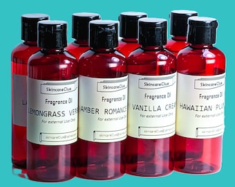 May include: A collection of red-tinted fragrance oil bottles with black caps and white labels. The labels display the brand name "Skincare Clue" and various scents like "Lemongrass Verbena" and "Vanilla Cream". The bottles are for external use only.