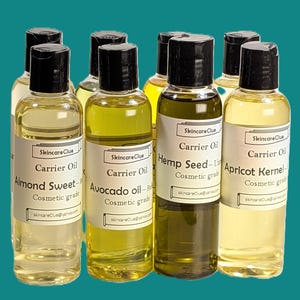 以下が含まれることがあります： 黒いキャップが付いた透明なガラス瓶のコレクション。アーモンドスイート、アボカド、ヘンプシード、アプリコットカーネルオイルなどのキャリアオイルが入っています。ラベルには「Skincare Clue」の文字が記載されています。