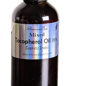 May include: A dark brown glass bottle with a black cap. The label reads "Skincare Clue Mixed Tocopherol Oil 95% (Cosmetic Grade)" with the website skincareclue.yahoo.com.
