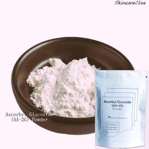 Op de afbeelding: Een bruine kom gevuld met wit Ascorbyl Glucoside poeder, naast een witte verpakking met het label "Ascorbyl Glucoside (AA-2G) Powder." De tekst "Skincare Clue" staat bovenaan. Het poeder is cosmetische kwaliteit.
