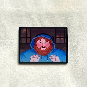 Könnte beinhalten: Ein rechteckiger Aufkleber mit einer Cartoon-Illustration einer Person mit rotem Bart und lockigem Haar, die einen blauen Kapuzenpullover trägt. Die Person hat einen überraschten Gesichtsausdruck mit erhobenen Händen vor einem dunklen Hintergrund.