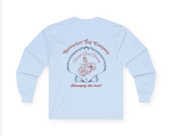 May include: Light blue long-sleeve shirt with a graphic on the back. The graphic features a seashell design with the text "Nantucket Tug Company Small Boat Society" and "Shrimply the best!" in red and blue.