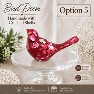 May include: A bird figurine crafted from red and white crushed shells, positioned on a clear glass pedestal stand. The text on the image reads Bird Decor, Option 5, Handmade with Crushed Shells, Unique Design, Handmade with Care, and Great Gift.