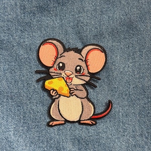 May include: Embroidered patch featuring a cartoon mouse holding a piece of yellow cheese. The mouse has gray fur, pink ears, and a red tail. The patch is on a blue denim background.