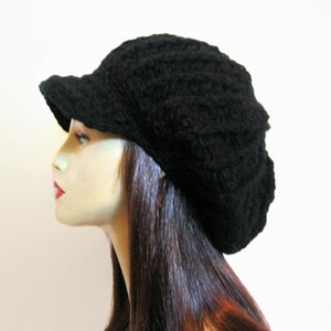May include: A black crocheted beanie with a brim. The beanie is slouchy and has a textured knit.