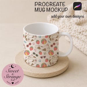 May include: A white ceramic mug featuring a repeating pattern of cartoon cats, strawberries, beach balls, and sunglasses. The text PROCREATE MUG MOCKUP add your own designs appears at the top, and a circular logo for Sweet & Strange Co. is visible.