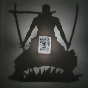 Puede incluir: Un cartel en blanco y negro de "Se Busca" con Roronoa Zoro de One Piece, con una sombra del personaje sosteniendo espadas. El cartel está centrado, con la sombra del personaje y espadas que lo rodean.