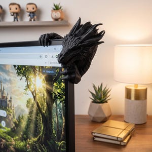 Rear and side view of a 3D-printed dragon monitor decoration showing its curved scaled neck wrapping behind the screen corner. The dragon’s horned head projects beside the monitor while its claws hold the bezel, demonstrating how the fantasy computer accessory appears from the back and side.