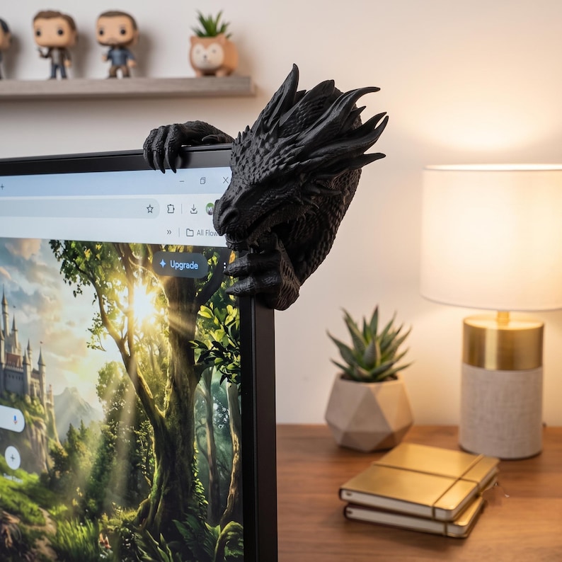 Rear and side view of a 3D-printed dragon monitor decoration showing its curved scaled neck wrapping behind the screen corner. The dragon’s horned head projects beside the monitor while its claws hold the bezel, demonstrating how the fantasy computer accessory appears from the back and side.