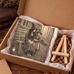 May include: A square wooden plaque featuring a sepia-toned photograph of two figures in pointed hats standing near a rustic wooden building, accompanied by a small wooden display easel, all packaged inside a cardboard gift box with white tissue paper.