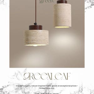 May include: Two beige cylindrical pendant lights with a textured surface hang from brown cords. The lights have a dark brown base and emit a warm glow. The word "green" is at the top, and the word "GREENLEAF" is at the bottom.