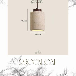 May include: A cylindrical pendant light fixture with a beige textured shade, 16.5cm in height and 11cm in diameter. It has a brown top and a brown cord. The word "green" is above the light fixture.