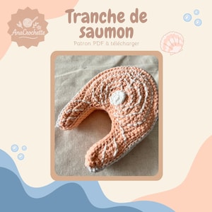 Peut inclure: Une tranche de saumon crochetée en pêche et blanc, avec des coutures détaillées imitant la texture du poisson. Le texte "Tranche de saumon" et "Patron PDF à télécharger" sont visibles. Le logo AnaCrochette est en haut à gauche.