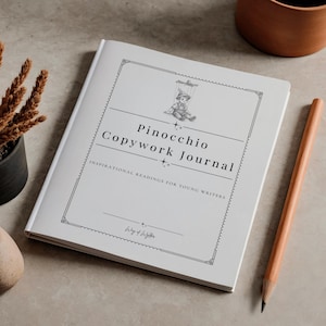 May include: A white journal titled "Pinocchio Copywork Journal" with a line drawing of Pinocchio as a puppet. The journal includes the text "Inspirational Readings for Young Writers" and a pencil.