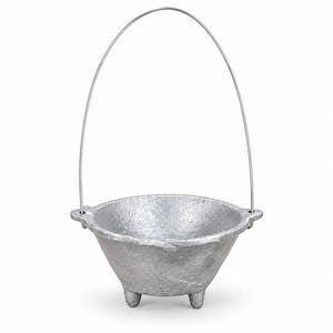 May include: A silver-colored metal cauldron with a textured, rough surface finish. The bowl features three short, sturdy legs at the base and two small side lugs that hold a thin, arched wire handle extending upward from the top rim.