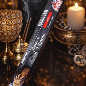 May include: A package of sage incense sticks with the text "Remove Evil Spirits". The black and red box features a person with a frightened expression. Incense smoke rises in the background, along with a lit candle and decorative items.