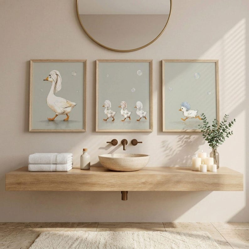 May include: Three framed prints featuring watercolor illustrations of geese in a bathroom setting. One print shows a goose with a towel on its head, another shows three geese, and the last shows a running goose with a blue hat.